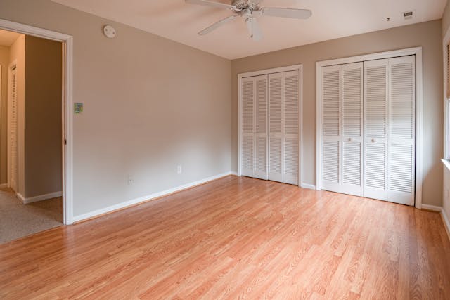 Empty room with hardwood floors and white closet doors