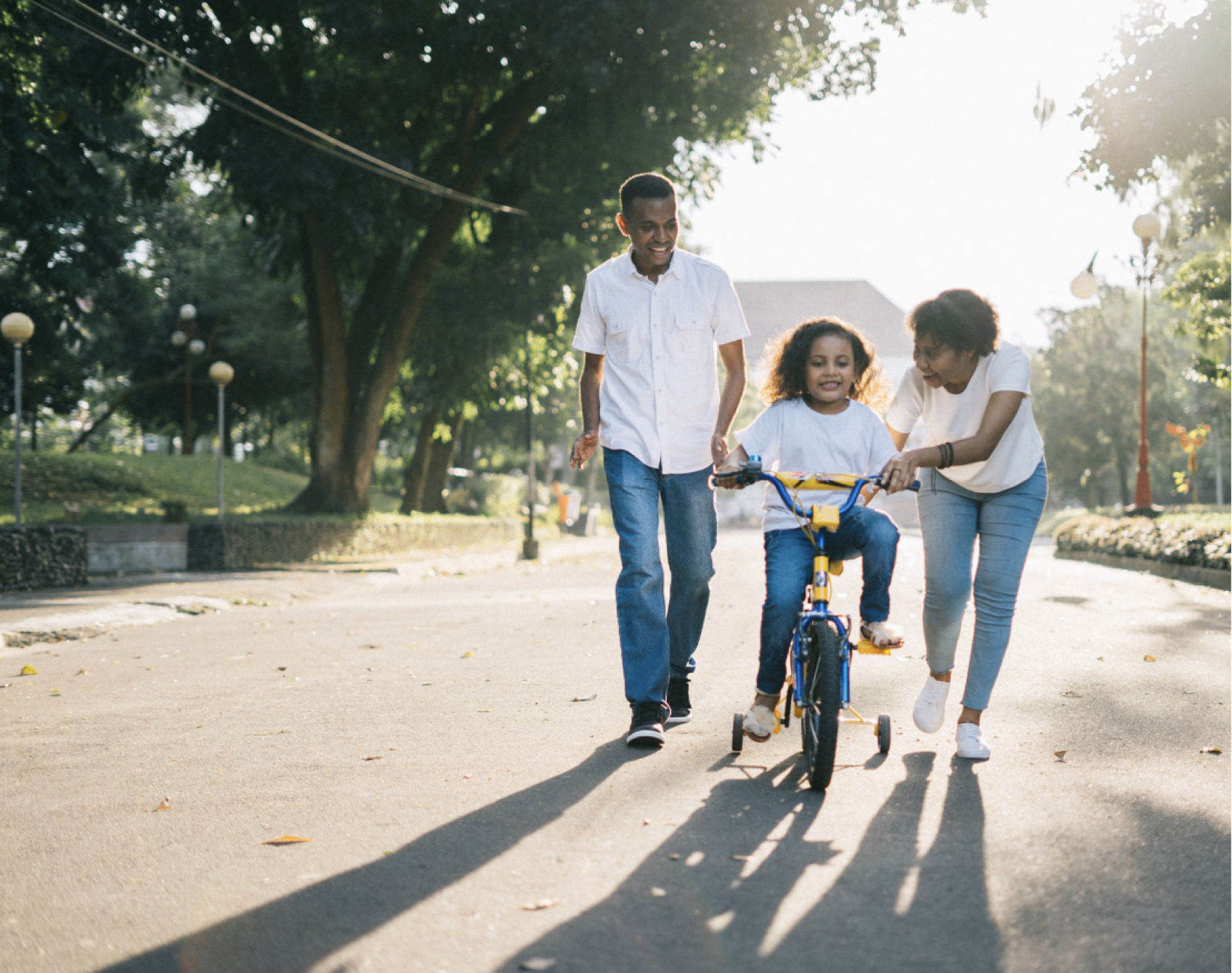 parents teaching child how to ride bike