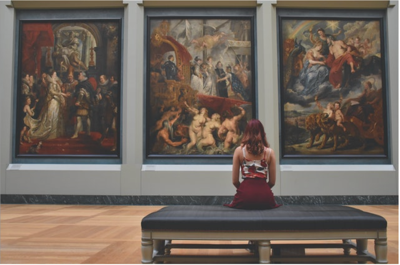 person with red hair looking at museum paintings