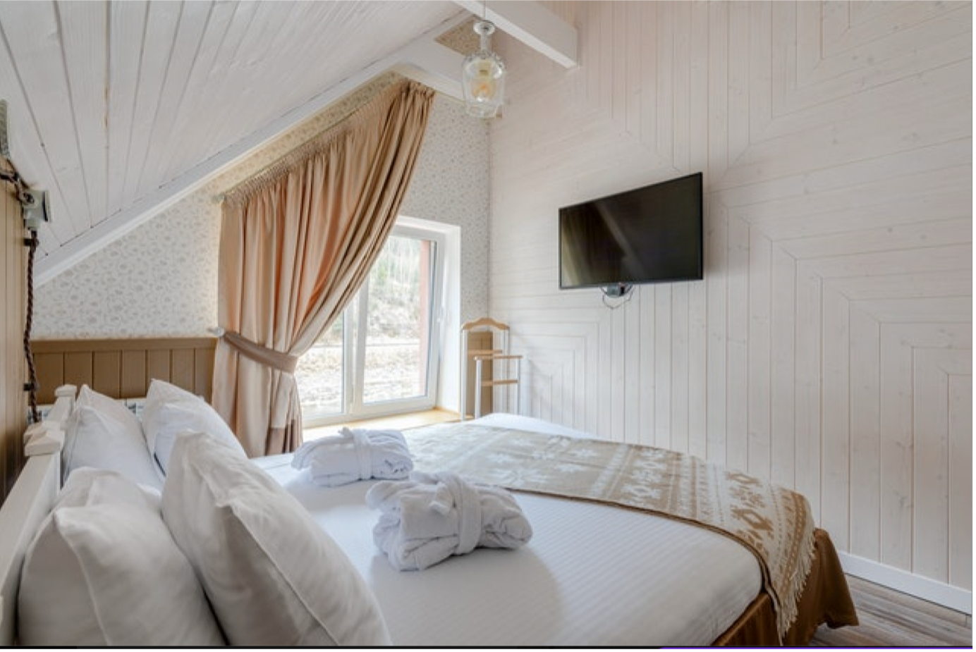 white and beige bedroom with window and television