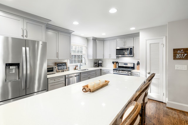 kitchen with white granite island and stainless steel appliances