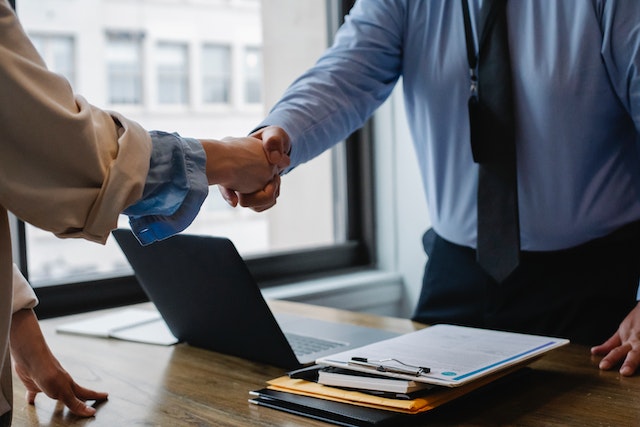 shaking hands over a desk